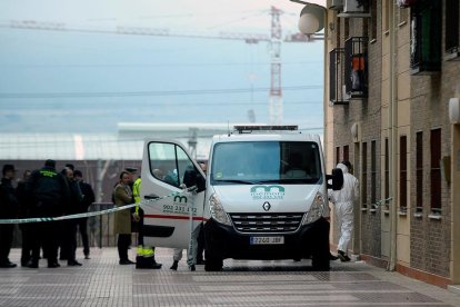 Un vehicle dels serveis funeraris espera al domicili de Azuqueca d'Henares on han tingut lloc els fets.