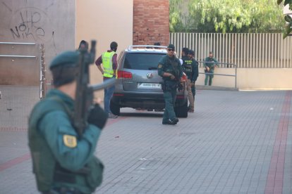 Imatge de diversos efectius de la Guàrdia Civil a Vinaròs, amb un agent amb arma llarga, desenfocat i en primer terme. Imatge del 22 de setembre del 2017