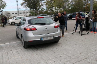 Plano abierto del vehículo no logotipado de la Guardia Civil saliente del CTTI después del cacheo.