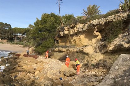 Los operarios trabajando, ayer, en la trituración de las rocas, en la playa del Fortín de Altafulla.