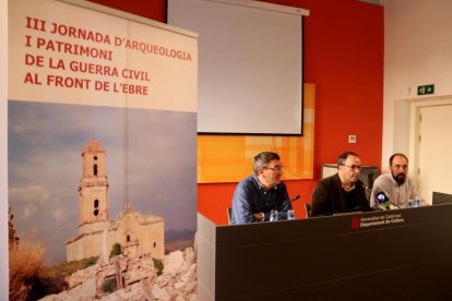 Imatge de la presentació de la III Jornada d'Arqueologia i Patrimoni de la Guerra Civil al front de l'Ebre amb el cartell en primer terme.