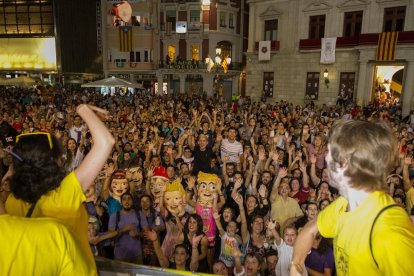 Membres del Col·lectiu del Masclet reparteixen bótes de la beguda al Mercadal, abans de la cercavila.