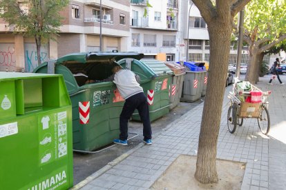 Imagen de una persona revolviendo los contenedores en Reus.