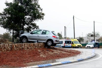 El cotxe suspès sobre el marge de pedra de la rotonda després d'impactar contra un pi. Imatge del 6 de febrer de 2018