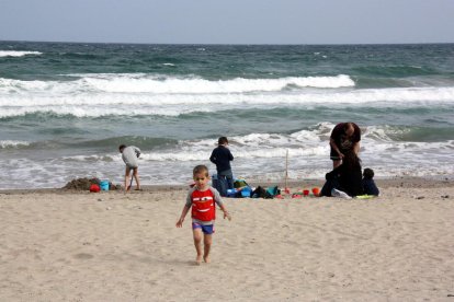 Imatge d'una família en una platja de la Costa Daurada