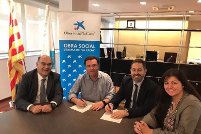 Imatge de Joan Maria Sardà, alcalde de La Pobla, i Alexis Gómez, director d'Institucions de Caixabank, signant el conveni.