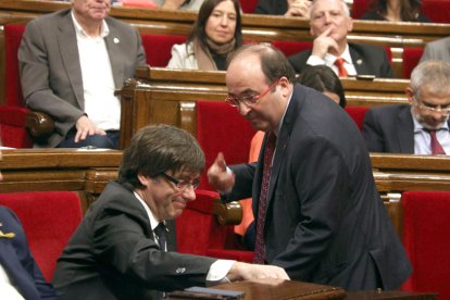 El primer secretario del PSC, Miquel Iceta, habla con el presidente de la Generalitat, Carles Puigdemont, en el Parlament.