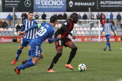 Karim Yoda intenta deshacerse de dos rivales del Lorca este domingo durante la goleada en el Estadi Municipal.