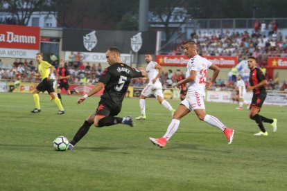 El central del CF Reus Pablo Íñiguez amb la pilota, al costat del grana Tejera.