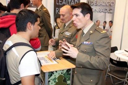 Un miembro del ejército explicando a un joven el funcionamiento del cuerpo en el stand del Expojove del 2017.