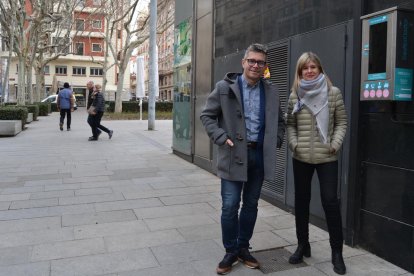 Los concejales Marc Arza i Noemí Llauradó delante del desfibrilador instalado en la plaza Llibertat.