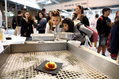 Un grupo de alumnos se interesa por el puesto de la Escola d'Hosteleria.