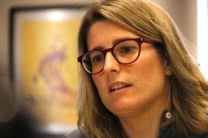 Primer pla de la portaveu de JxCat, Elsa Artadi, amb un quadre que representa el Parlament al fons, durant l'entrevista amb l'ACN