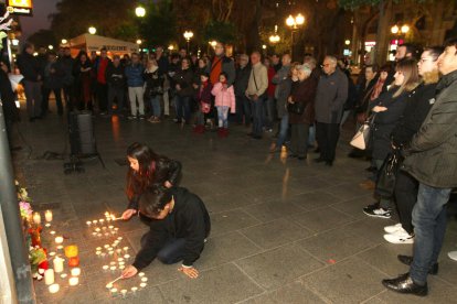 Un nen i una nena encenen espelmes al lloc on la Carolina va morir el passat 9 de febrer.