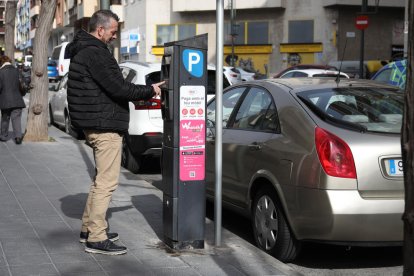 Un ciutadà paga a un dels parquímetres de la ciutat de Tarragona després d'aparcar a la zona regulada.