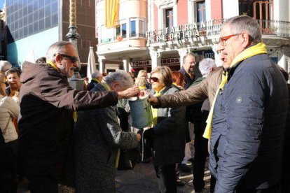 Pla mig de dos manifestants aporten diners a la caixa de solidaritat durant la concentració per la llibertat dels presos a Reus.