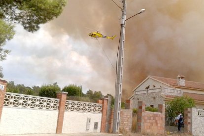 Imatge d'un helicòpter dels bombers sobrevolant la zona al costat de la urbanització.