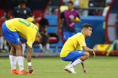 Roberto Firmino y Philippe Coutinho en el césped al final del partido ante Bélgica.