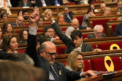 El portaveu adjunt de JxCat Eduard Pujol i el president d'ERC, Sergi Sabrià, marquen el sentit del vot durant el debat de la reforma de la llei de Presidència al Parlament.