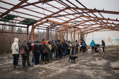 Un grup de joves fan cua a l'hora de dinar en un campament ubicat en la frontera entre Sèrbia i Croàcia, el passat mes de març.