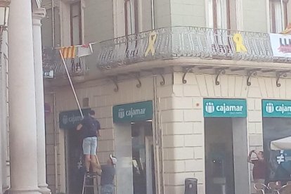 Imatge dels individus traient la pancarta sobre els presos polítics de l'Ajuntament de Reus.