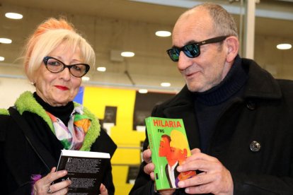 Plano medio de Elisabeth Sabala y Fernando Martínez García, en la Biblioteca Marcel·li Domingo de Tortosa, hojeando algunas de las novelas de FMG ilustradas con pinturas de los dos.