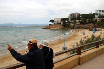 Plano general de la playa de los Curas de Salou, con unos turistas en primer término.