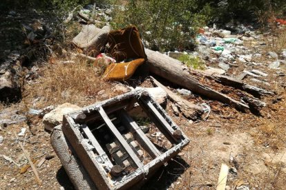 Restos de lo que queda de una butaca, a pocos metros de material de todo tipo abandonado a tierra.