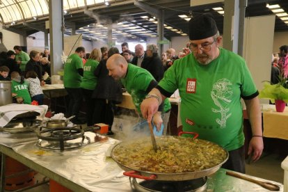 Pla mig d'un home cuinant arròs amb galeres i carxofa a la Festa de la Carxofa d'Amposta.