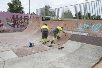 Operarios trabajan para recuperar la superficie del 'half-pipe' del parque.