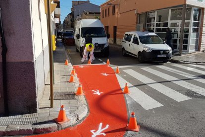 Un operari pintant la nova senyalització horitzontal en un pas de vianants.