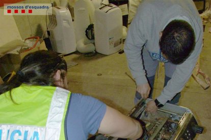 Dos agents dels Mossos desmunten una cafetera amb marihuana.