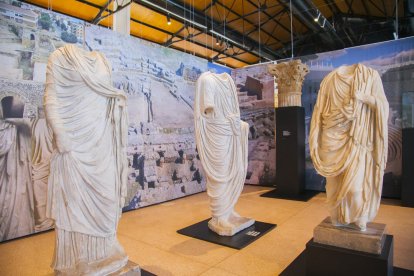 Tres estàtues, la de l'esquerra d'una dona, i, com a fons, fotografies de l'Amfiteatre i del Teatre de la ciutat romana de Tarraco.