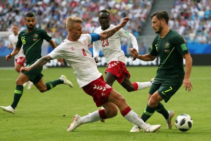 El jugador australiano Leckie lucha con el central danés Simon Kjaer.