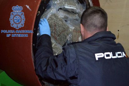 Un agent de la policia espanyola inspeccionant el cilindre pintant de la furgoneta interceptada.