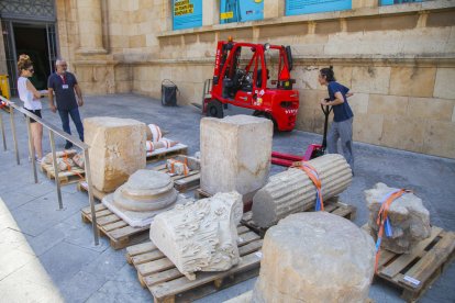 Un operario se dispone a trasladar piezas hasta una furgoneta, ante la atenta mirada de personal vinculado al museo.