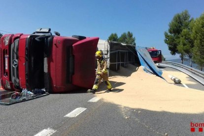 La càrrega del vehicle, que transportava cereals, ha quedat estesa a la via.