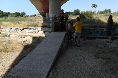 Dos ciclistes creuen el Francolí per la passera.