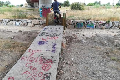 La rampa d'accés al pontet de fusta i algunes zones ja estan plenes de pintades.