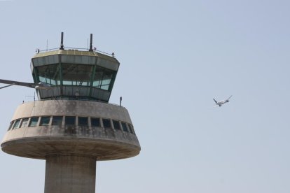 Un avió enlairant-se amb l'antiga torre de control al costat.