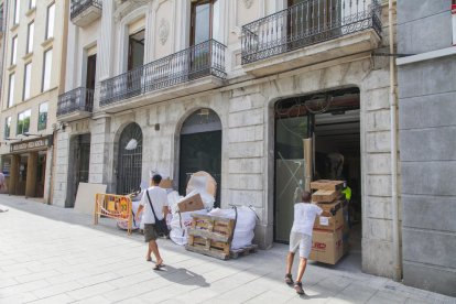 Un operario introduce material en la que será la nueva oficina de CaixaBank en la Rambla Nova.