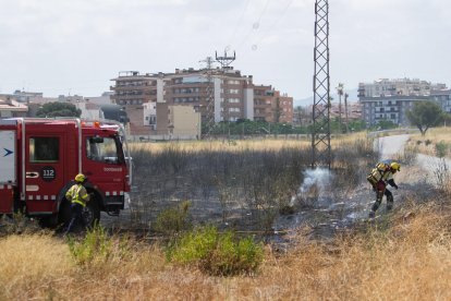 Tres dotacions de Bombers es troben treballant al solar per extingir el foc.