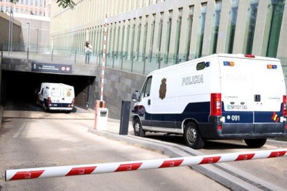 Pla mitjà des de darrere de dues furgonetes de la policia espanyola entrant al parking subterrani de la Ciutat de la Justícia, el 25-5-18.