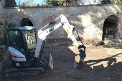 Una máquina procede a la limpieza del solar.