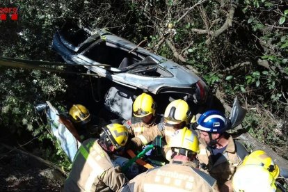 Los Bombers durante el rescate del conductor atrapado en el vehículo en el Pradell de la Teixeta.