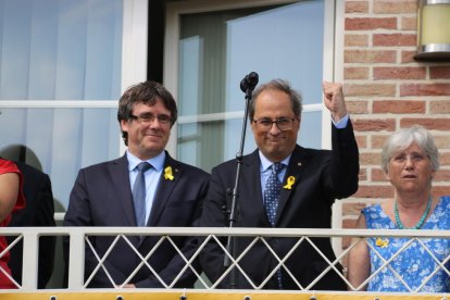 El president Quim Torra aixeca un puny al costat de Puigdemont, en un acte a Waterloo.