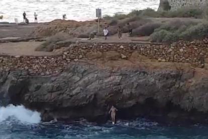 Instant on la primera noia es llença a l'aigua, sota l'atenta mirada dels altres tres menors.