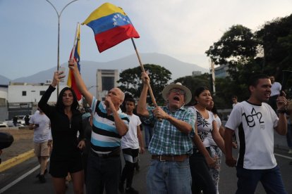 Simpatitzants del president interí Juan Guaidó fan onejar banderes aquest dimarts en la base militar La Carlota.