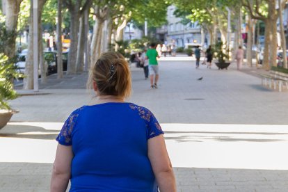 Una dona passejant un gos. Imatge d'arxiu.