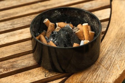 Imagen de un cenicero en la mesa de una terraza de bar.